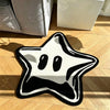 A black and white decorative pentagram rug lying on a wooden floor.