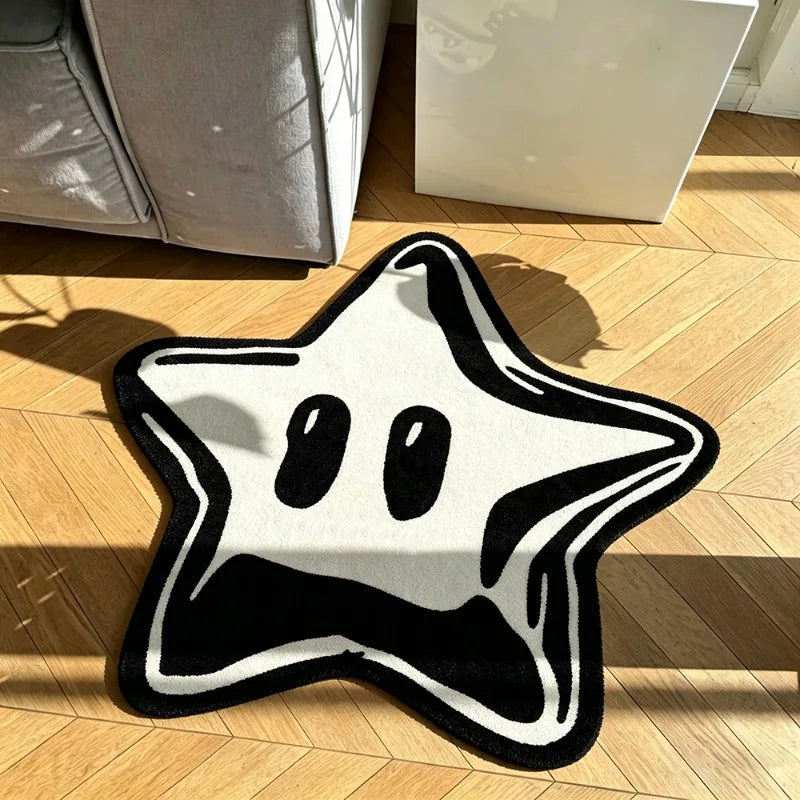 A black and white decorative pentagram rug lying on a wooden floor.