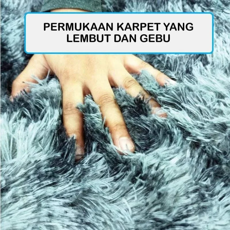 A hand gently touches a soft, fluffy gray velvet carpet mat.