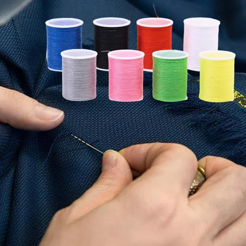 A hand is shown sewing a colorful thread into a stack of yarn or thread spools on dark fabric.