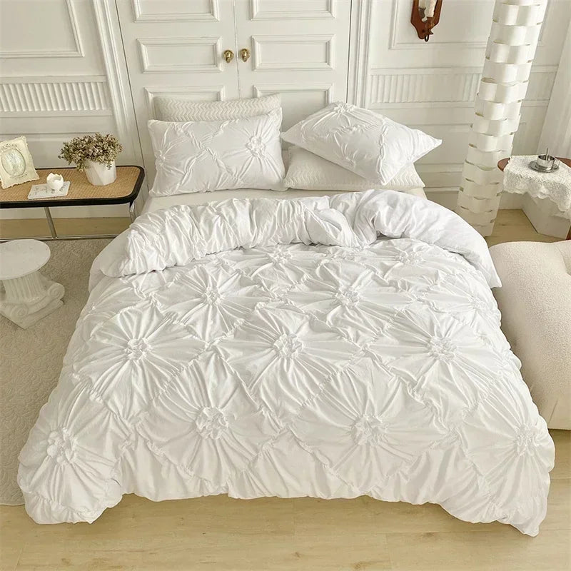 White quilted duvet cover set displayed on a bed with white paneled walls and light wood flooring.