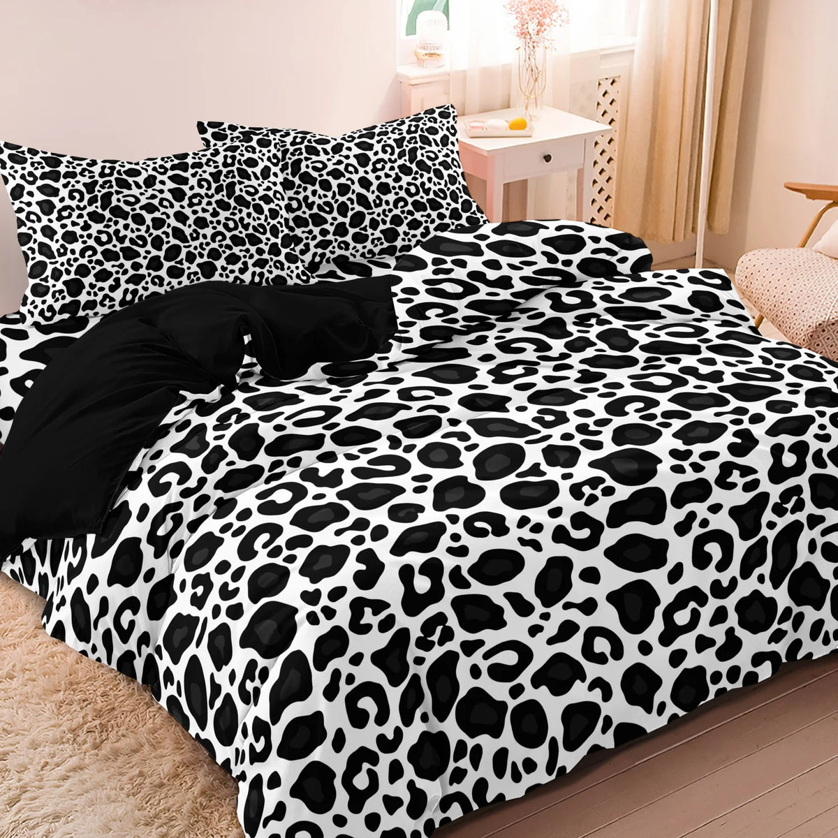 A leopard print duvet cover set featuring black and white spots on a bed.