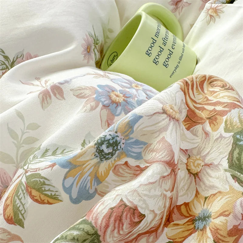 A close-up of floral cotton pillow covers in cream and pale green, showing a rolled tag with 'good morning' text.