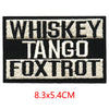 Black embroidered letter patch featuring the text WHISKEY TANGO FOXTROT in white thread