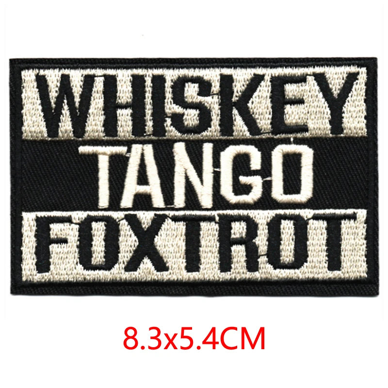 Black embroidered letter patch featuring the text WHISKEY TANGO FOXTROT in white thread