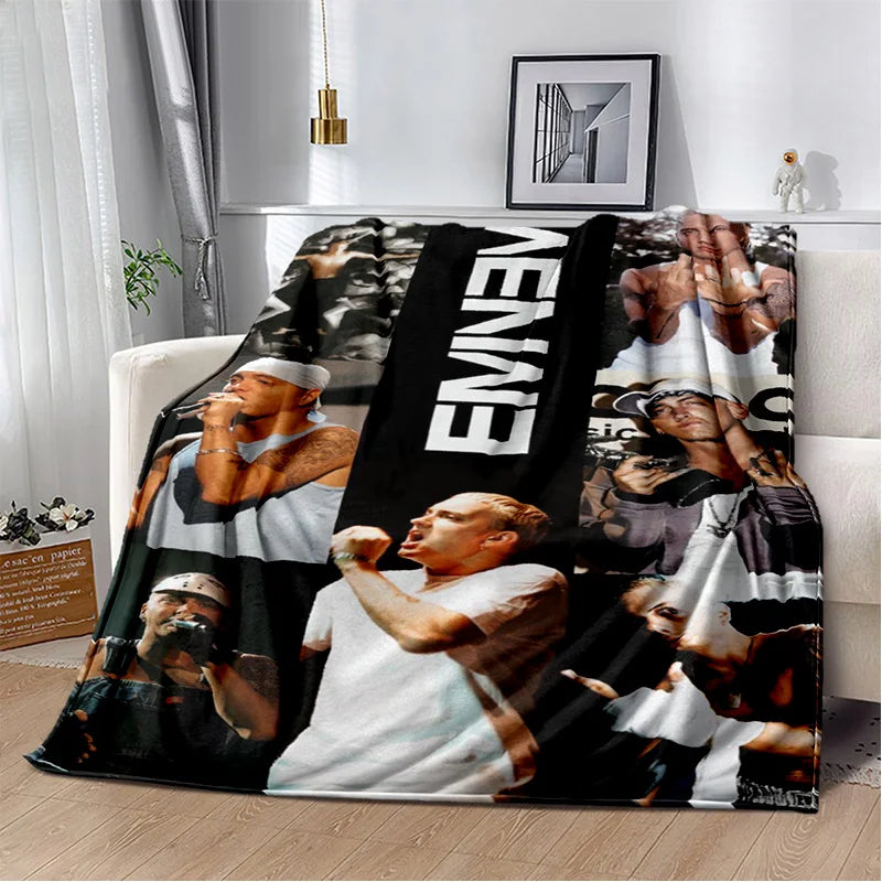 A black and white graphic throw blanket featuring multiple portraits of Eminem.