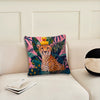 A cushion cover featuring a cheetah face and tropical leaves in pink, green, and orange tones.