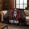 A dark flannel throw blanket featuring a distressed, screaming horror character design in red and white.