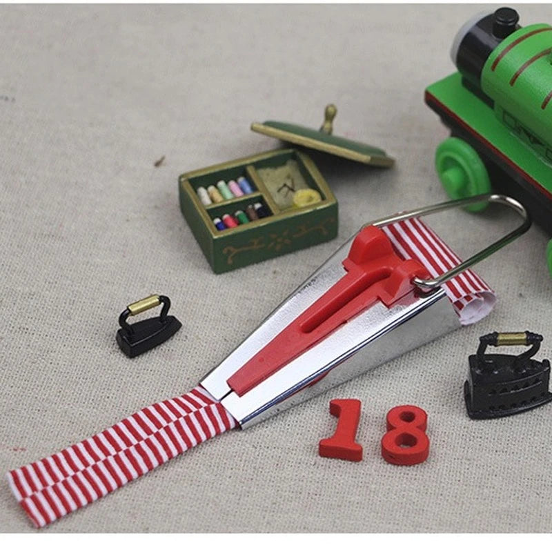 A precision bias tape maker set featuring a red and silver tool with numbered tape pieces on a light fabric background.
