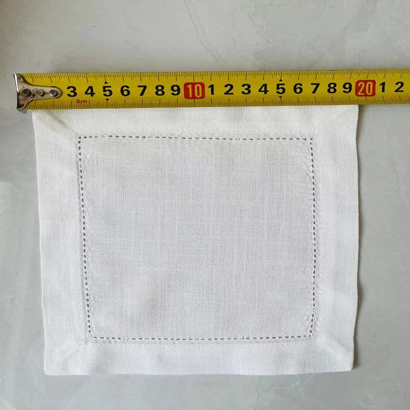 A white linen napkin or table linen square is shown next to a ruler for scale.