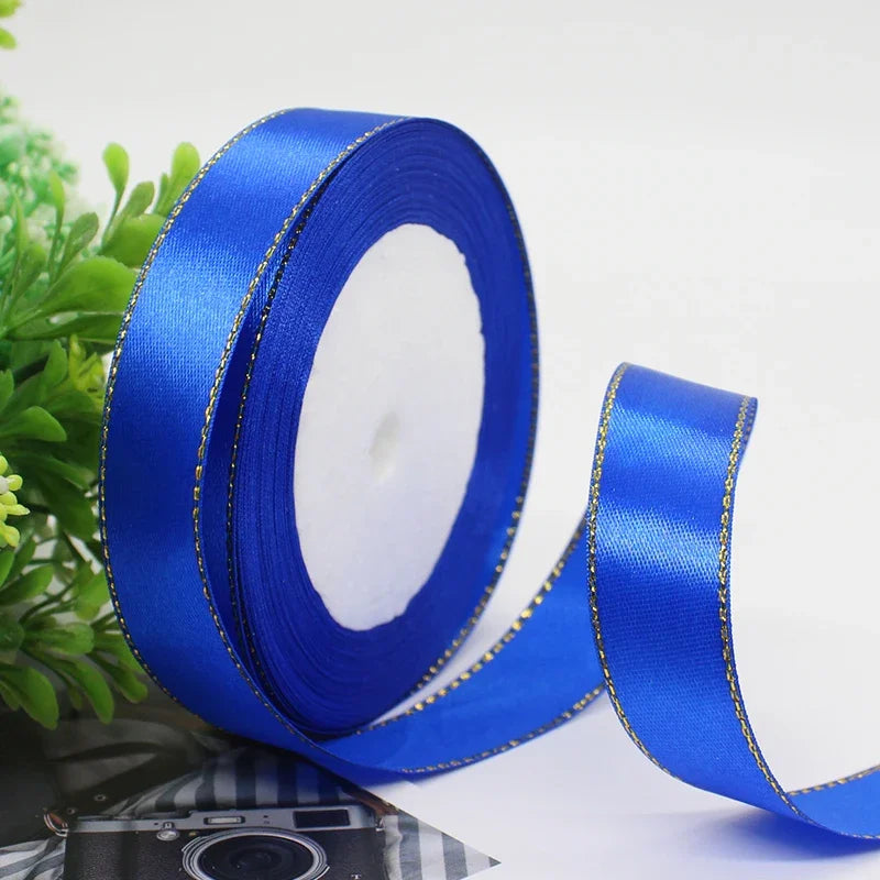 Blue satin ribbon with a gold edge rolled on and unwound, ready for gift wrapping or crafts.