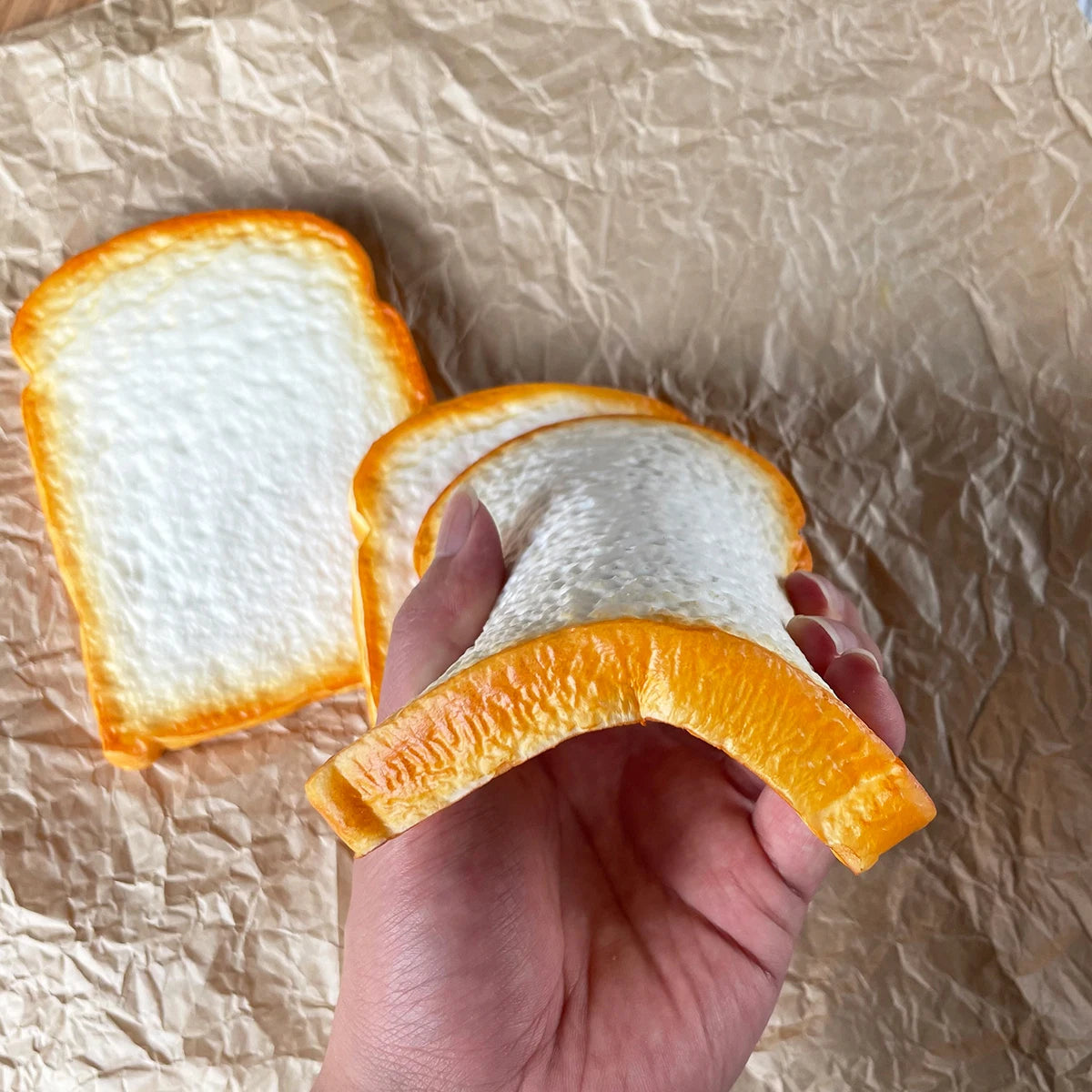 A hand holds a slice of realistic PU toast, showing the golden-brown texture against a crumpled brown background.
