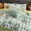 A plush rabbit hair bedding set featuring soft mint green and white textures on a bed.