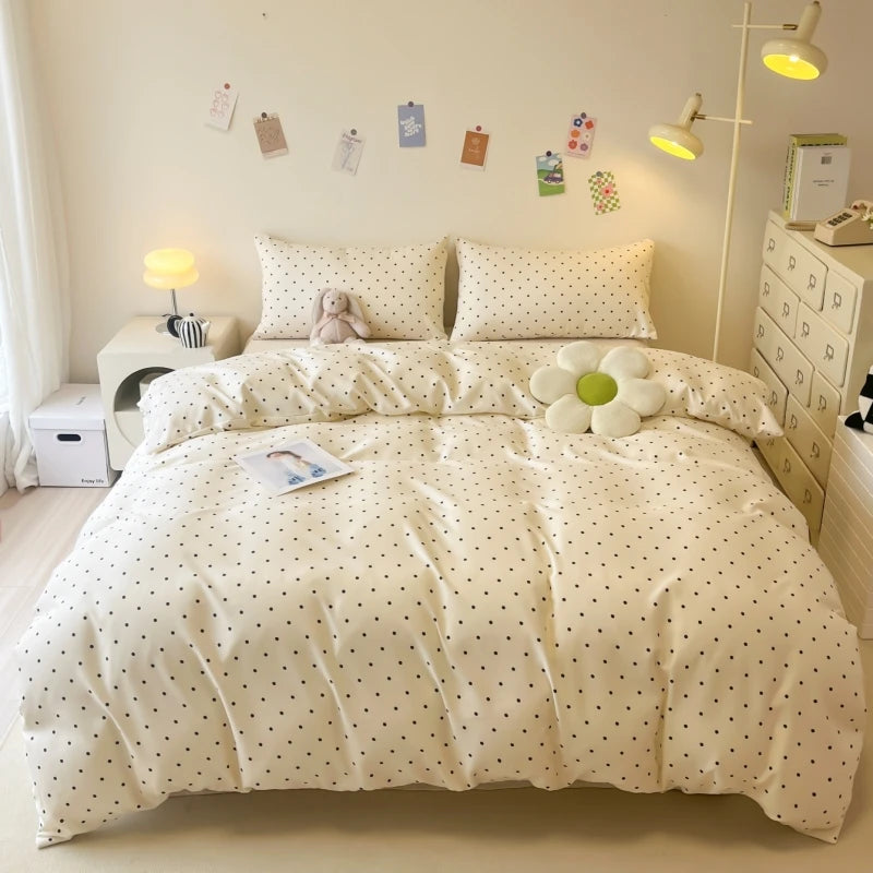 A white duvet cover set with a subtle polka dot pattern displayed on a bed in a bright room.