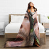 A woman is draped in a cozy flannel throw blanket featuring a portrait of Arthur Morgan.
