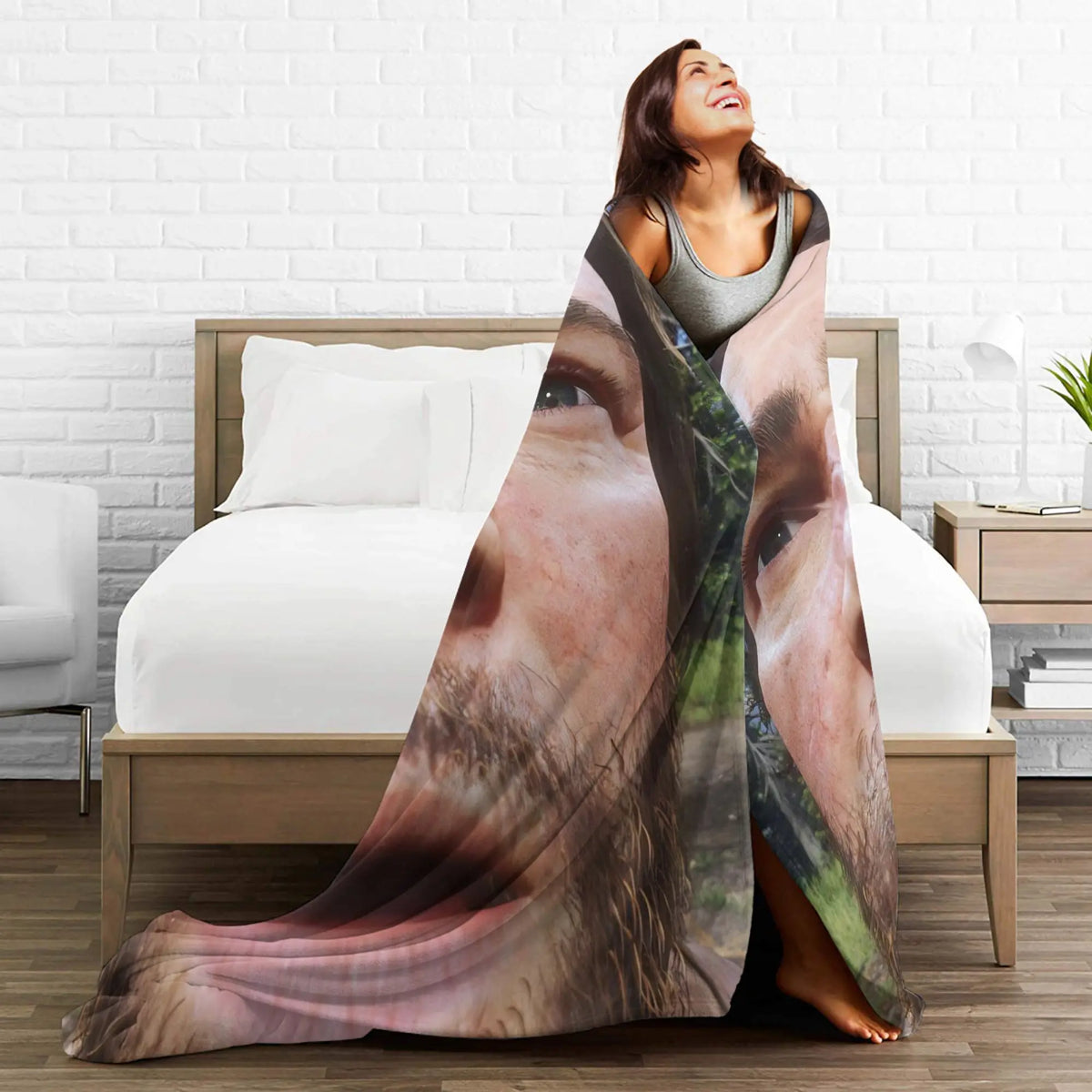 A woman is draped in a cozy flannel throw blanket featuring a portrait of Arthur Morgan.