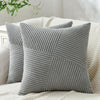 A single gray textured corduroy throw pillow cover with vertical ribbing resting on a cream-colored fabric.