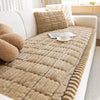 A beige corduroy sofa armrest cover with quilted texture resting on a white sofa.
