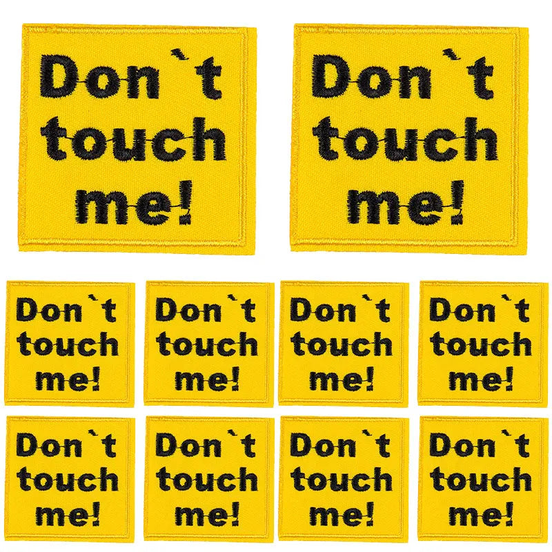 Four yellow embroidered patches with black text saying Don't touch me!