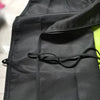 A black polyester apron is shown folded or hanging, featuring a drawstring closure.