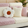 A collection of pink and cream textured throw pillows on a sofa.