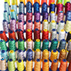 A row of various colored embroidery threads in spools displayed on a wooden rack.