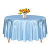 A light blue satin round table cloth set for elegant decor, featuring a small vase of yellow flowers.