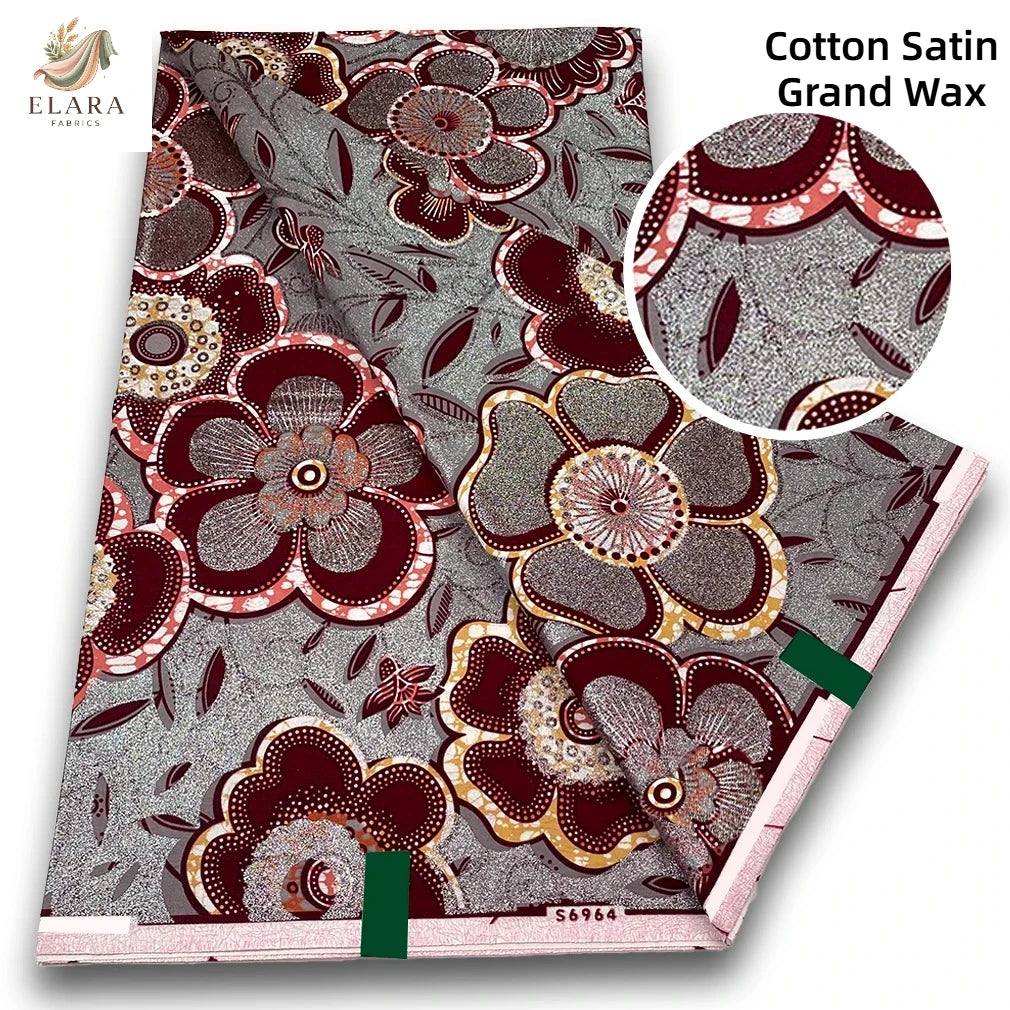 Close-up of Cotton Satin Grand Wax fabric featuring intricate floral patterns in maroon and gold tones.