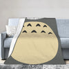 A fleece throw blanket featuring a stylized Totoro character design in beige and gray tones.