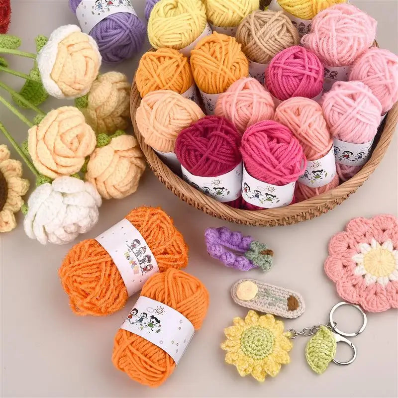 A collection of 12-color soft acrylic yarn skeins in various shades of pink, orange, yellow, and purple, displayed on a woode