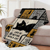 A black and gold patterned flannel throw blanket featuring cat motifs for ultimate comfort.