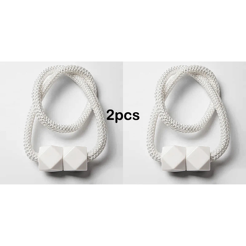 Two white decorative curtain tiebacks made of strong magnetic rope.