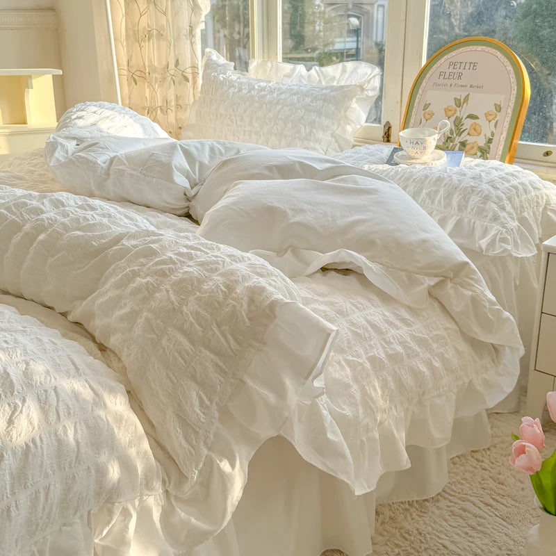 White lace seersucker duvet cover set displayed on a bed with sheer curtains and natural light.