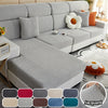A light gray Jacquard elastic sofa slipcover with white and orange accent pillows on a modern sofa.