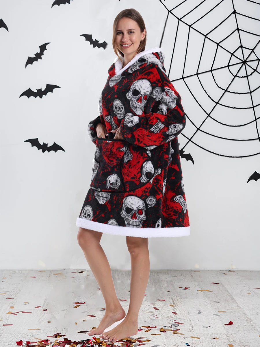 A woman models an oversized patchwork fleece hoodie with skull print against a white wall decorated with black bats and a spi