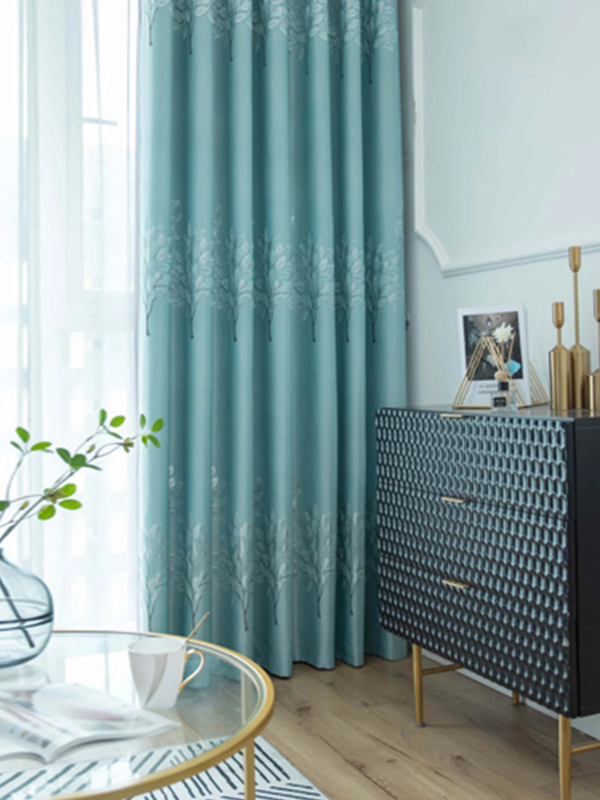 Light blue curtains featuring a white silhouette of trees against a pale background.