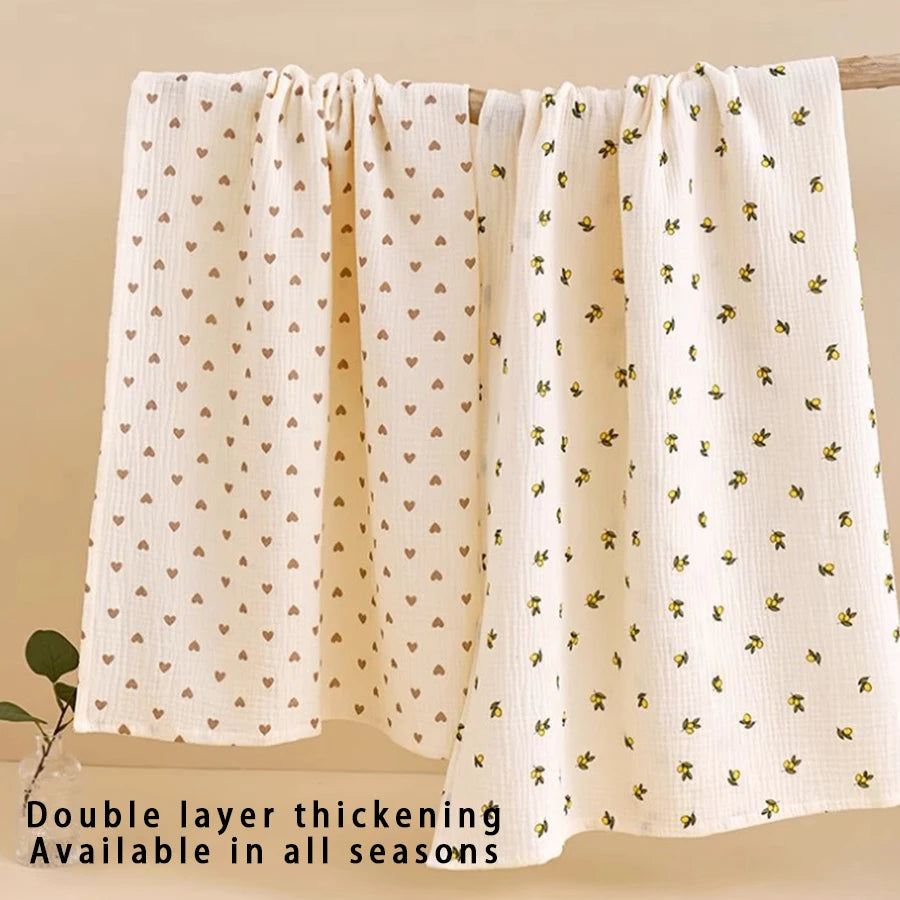 A cream colored double layer thickening baby swaddle blanket hanging on a wooden rod.