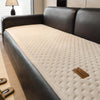A dark leather sofa with a beige quilted cushion and a matching brown leather accent tag.