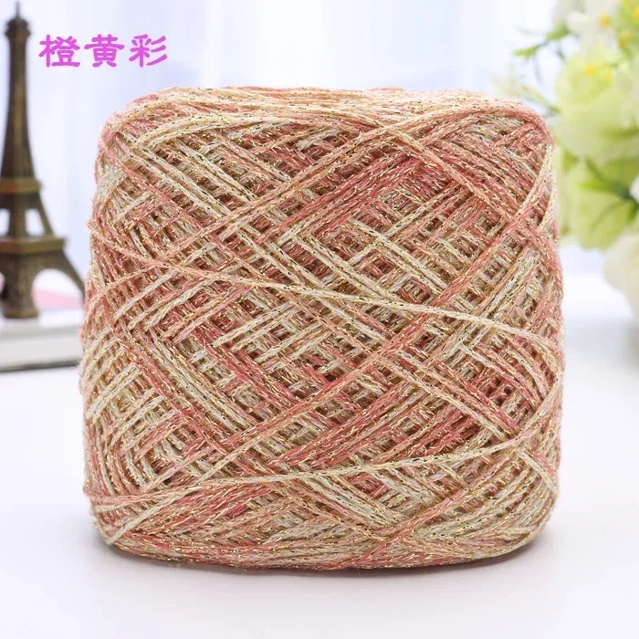 A ball of metallic silk crocheting and knitting yarn with a pinkish-gold color and woven texture.