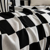 A black and white checkerboard fabric slipcover draped over a piece of furniture.