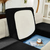 A black and white Jacquard sofa slipcover with elastic edges resting on a light blue surface.