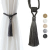 Elegant black curtain tiebacks with long gray tassels hanging from a rope