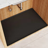 A black silicone liner mat is placed inside a wooden under sink cabinet, next to a faucet.