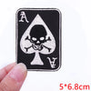 A black embroidered patch featuring an Ace of Spades design on a white background.