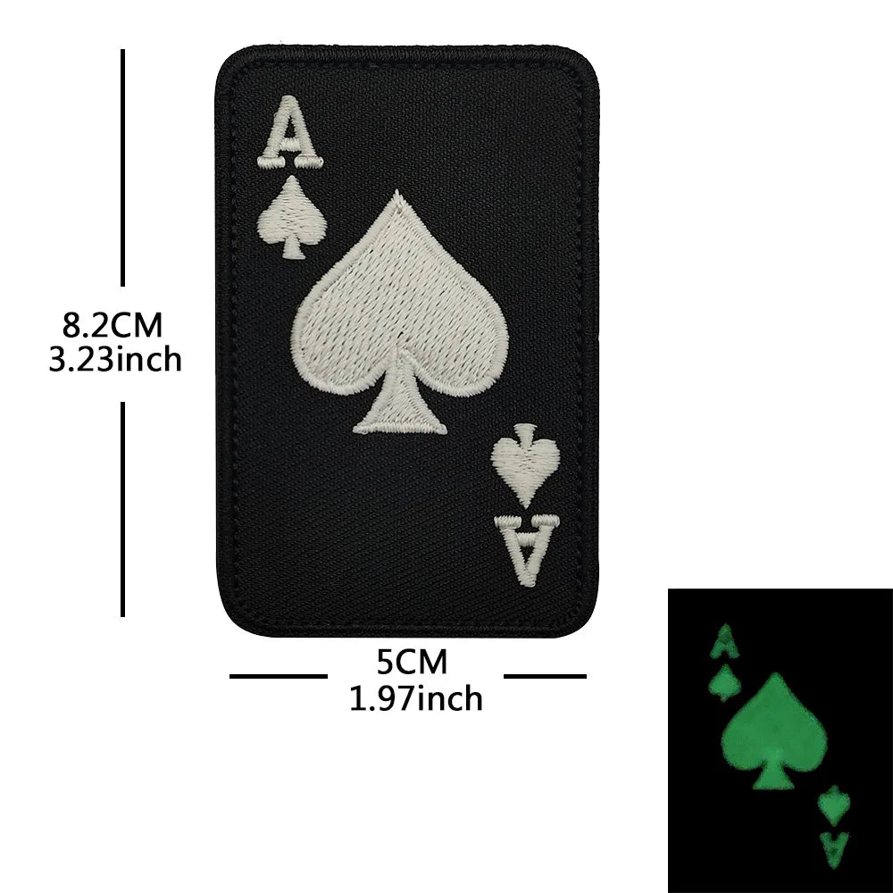 Black embroidered patch featuring a large spade, a small heart, and a diamond.
