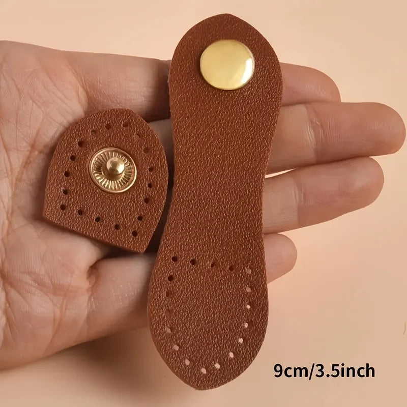 A set of eight brown leather bag buttons, including a gold-colored button, is held in a person's hand.