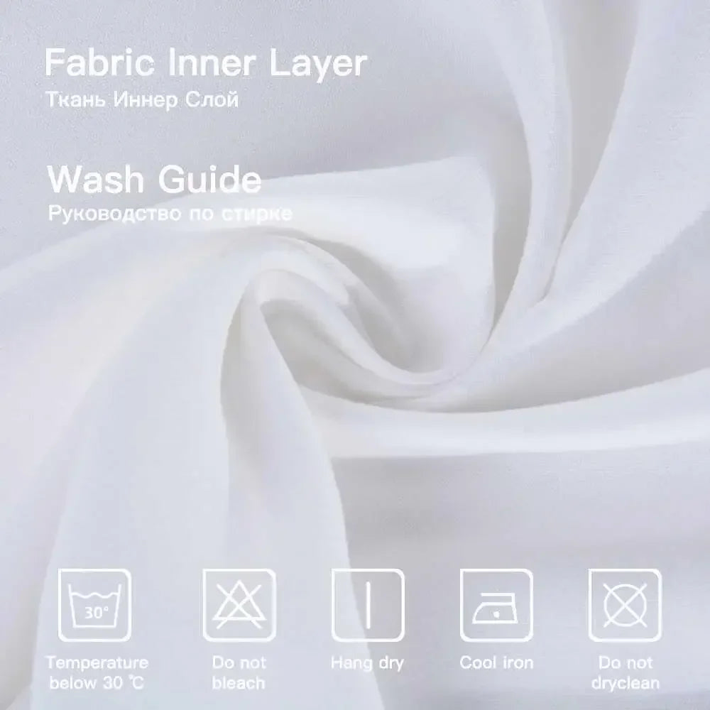 A white fabric inner layer with washing instructions displayed on a background of draped white fabric.