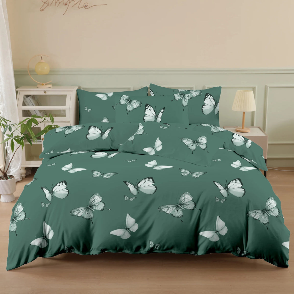 A dark teal duvet cover set featuring a white butterfly print on a bed.