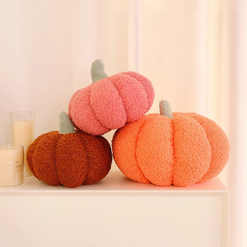 Three fuzzy 3D pumpkin shaped throw pillows in shades of pink, orange, and brown for autumn decor