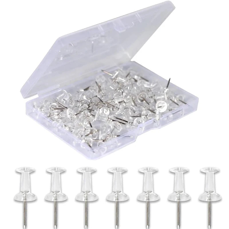A clear plastic container holding numerous push pins with steel tips.